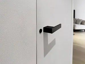 Detail of a modern matt black door handle with lock