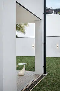 View of the side of a modern house with patio and garden