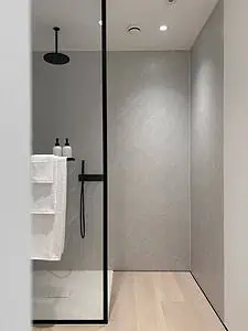 A black thermostatic rain shower and a glass shower screen with black frame