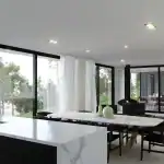 House design in Sri Lanka featuring open-plan living, dining and kitchen spaces, with a white marble island, marble dining table and suspended wood stove.