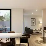 Open-plan living area in a modern house design in Sri Lanka with white marble dining table, modern hardwood chairs and view to the living room and kitchen