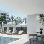 3D render of the covered outdoor dining area villa SW with view to the swimming pool with outdoor tanning beds on the patio