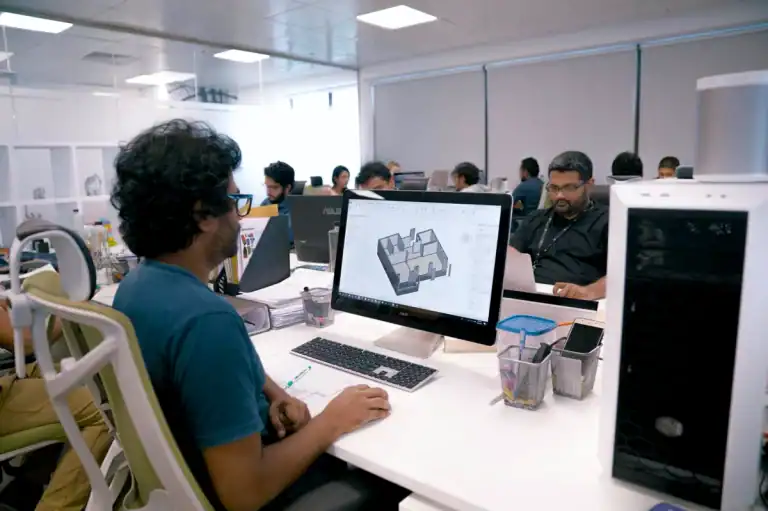 MVIVO architecture and design team working on 3D house models in an open-plan office environment