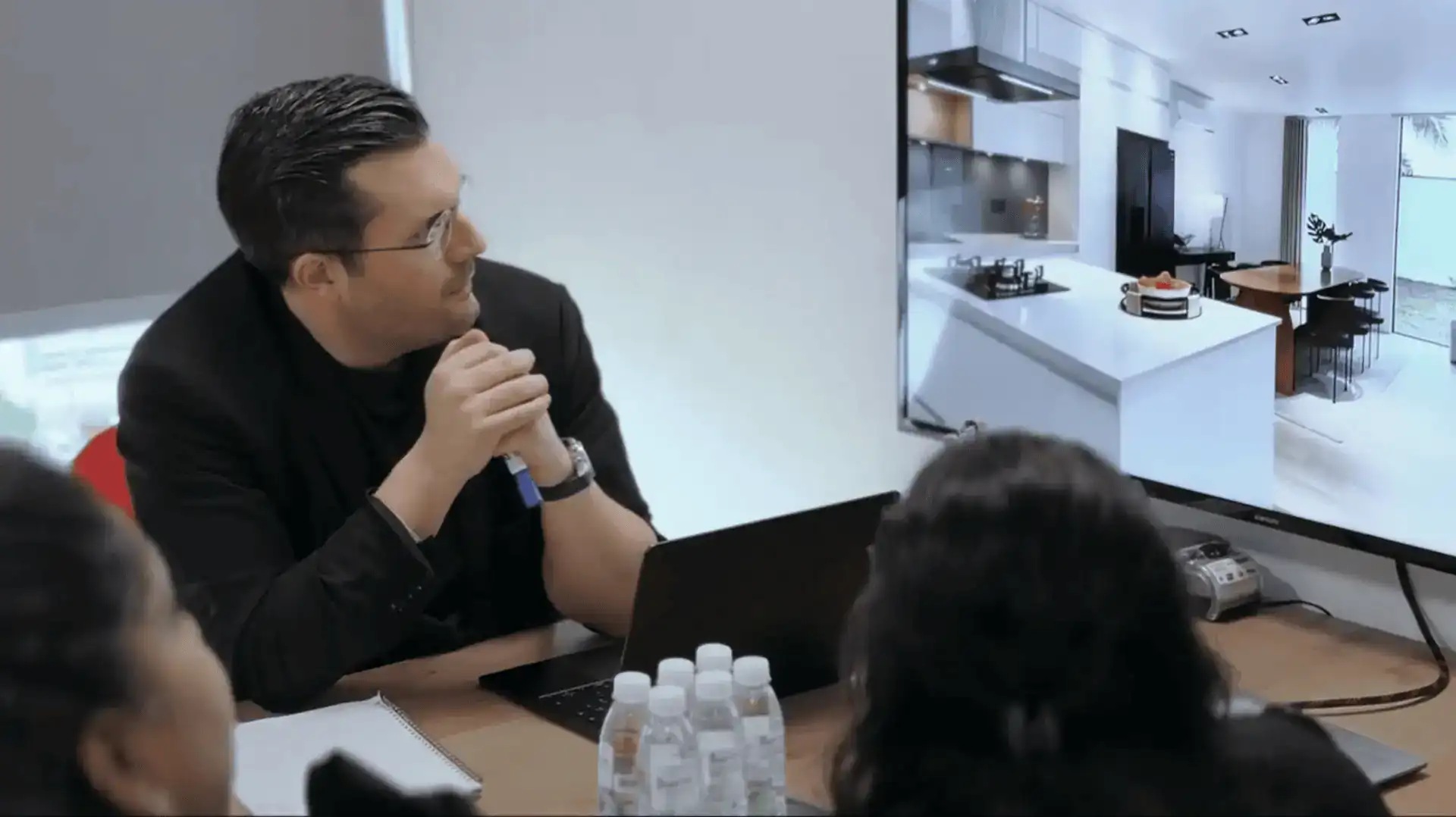 MVIVO team member presenting a 3D kitchen visual to clients during a design meeting using a large screen