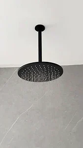 Black ceiling mounted rain shower with water running in a modern MVIVO bathroom.