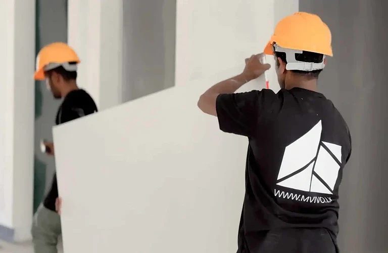 MVIVO workers carrying drywall during the process of building a house in Sri Lanka.