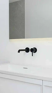 Bathroom vanity with black wall mounted mixer tap and solid surface basin.